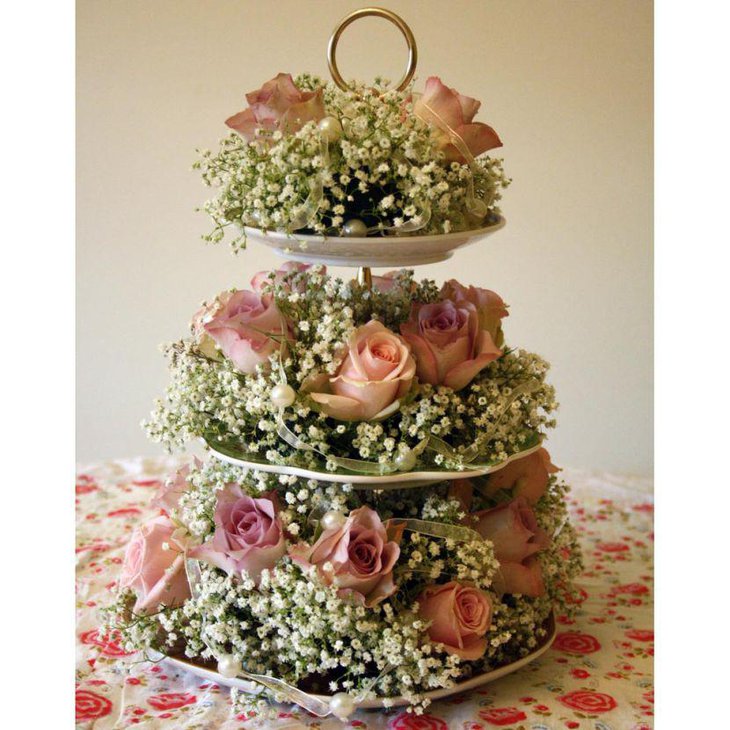 Vintage cake stand centerpiece with flowers on weddign table
