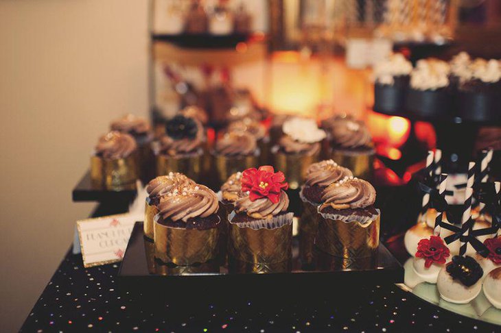 Vintage European themed dessert buffet table with golden toned cupcake wrappers