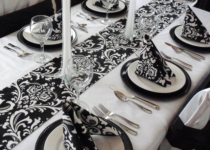 Wedding table setting with black and white table runner and napkins
