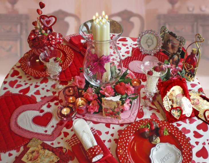 White candles in a glass jar centerpiece on Valentines table