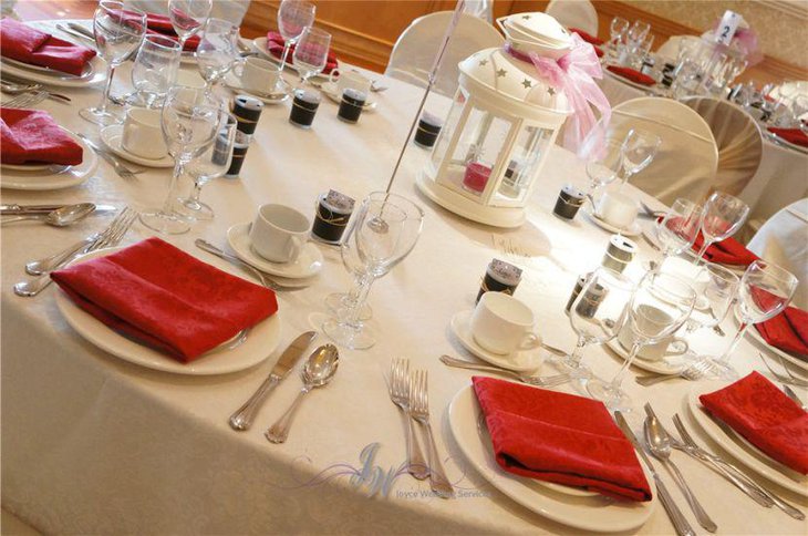 White lantern with red candle as decorative table centerpiece for weddings