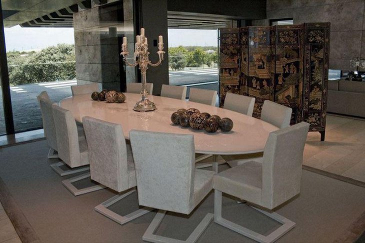 White oval granite dining table set with eleven chairs