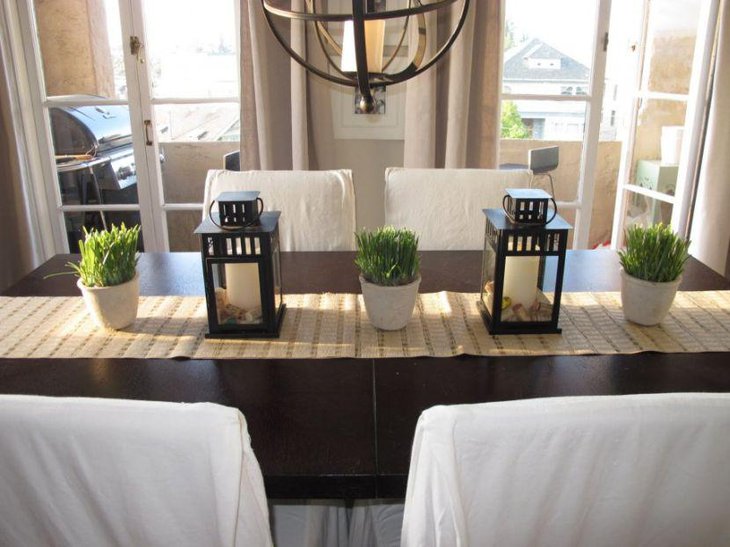 White pillar candle decor in black lanterns looks amazing