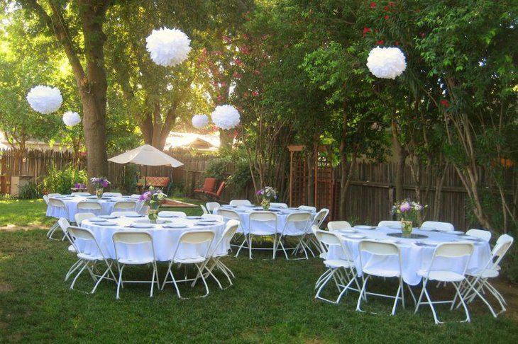 White themed bridal shower tables decorated with floral vases