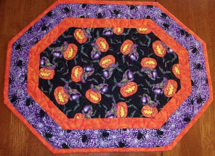Witch hats on Jack O Lanterns seen designed on this table runner