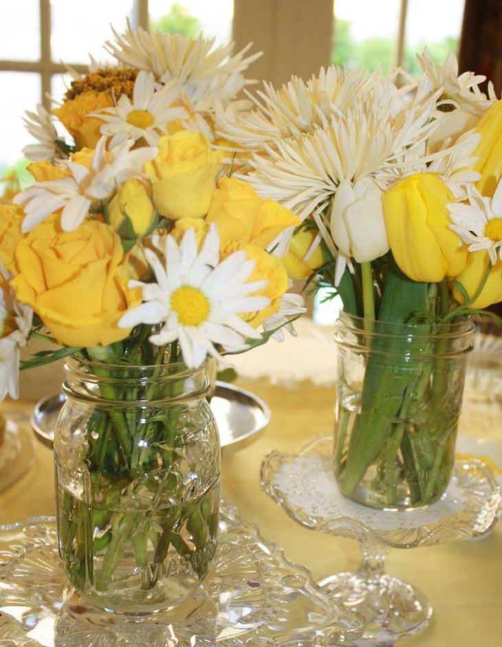 Yellow and white theme flower arrangement in naked mason jars